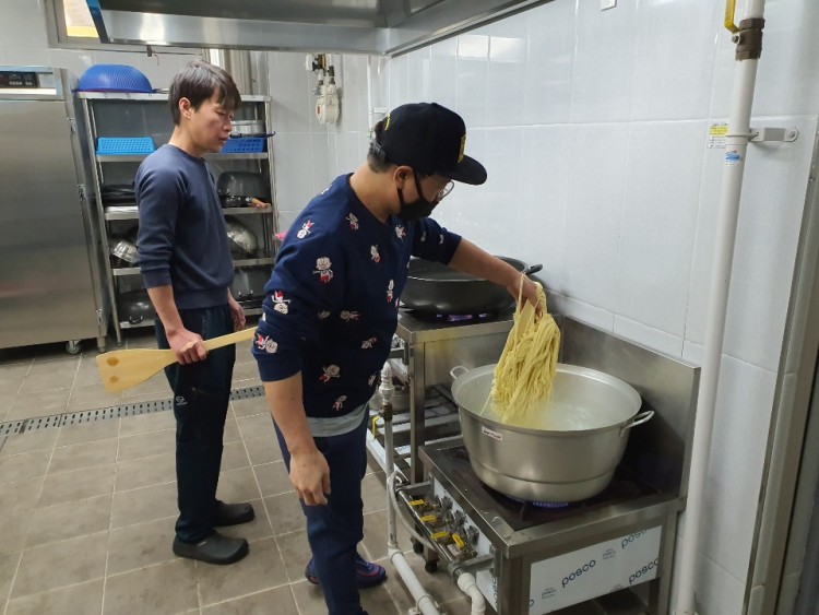 봉사자들이 주방에서 면을 삶고 있는 모습
