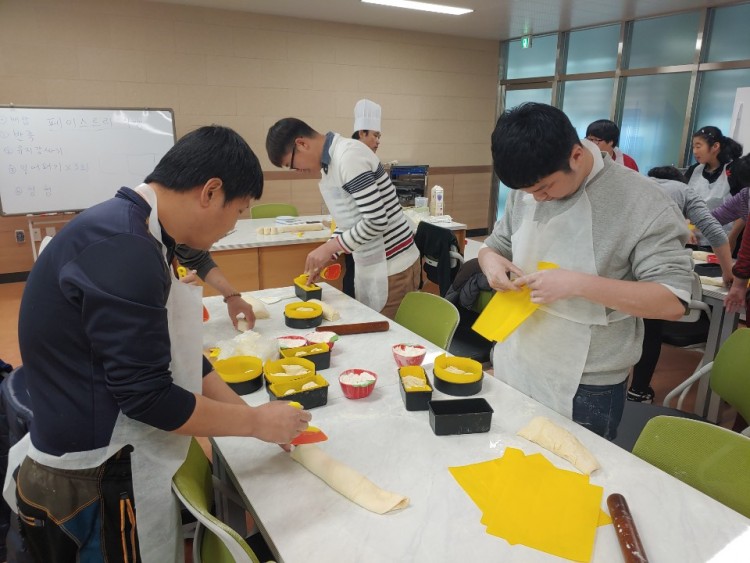 남성이용자들이 빵 반죽을 틀에 넣고 있는 모습